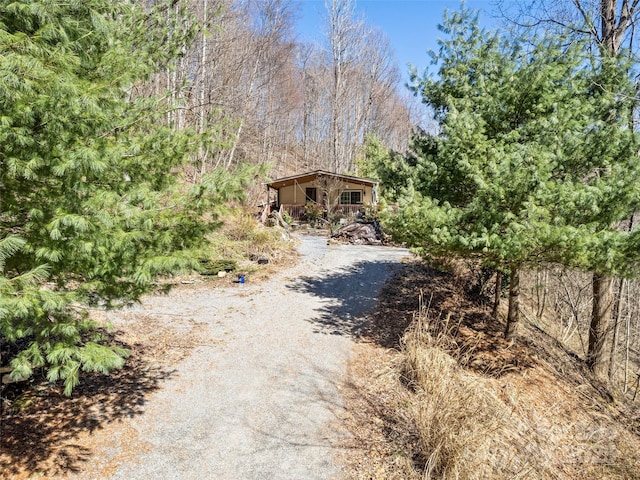 exterior space featuring a view of trees and driveway