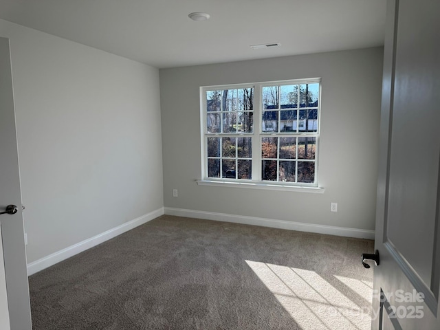 spare room featuring visible vents, baseboards, and carpet