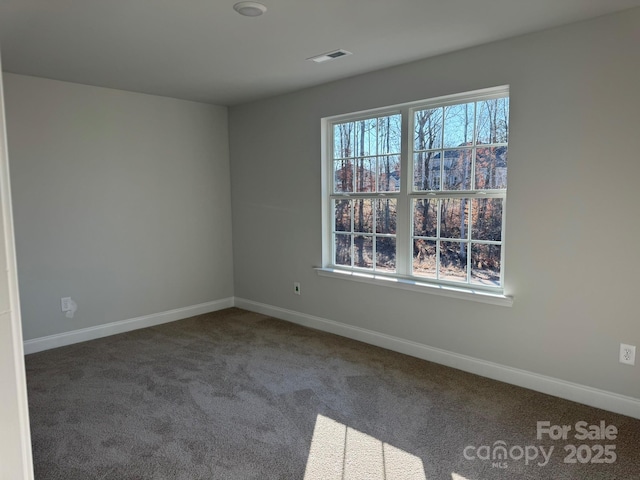 spare room with visible vents, baseboards, and carpet flooring