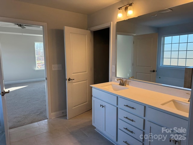 full bath with double vanity, a ceiling fan, tile patterned floors, and a sink