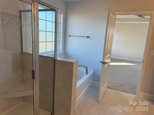 full bathroom featuring tile patterned floors, baseboards, a garden tub, and a shower stall