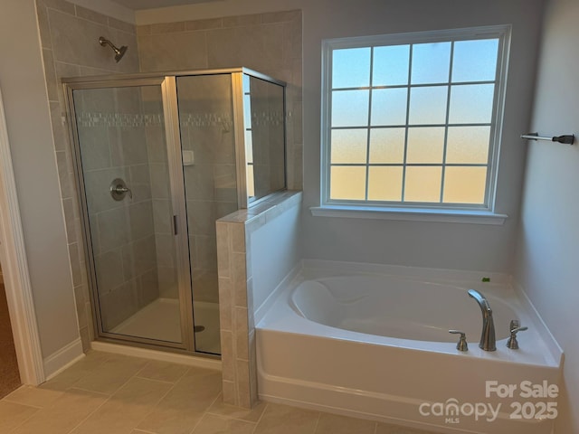 full bath featuring a garden tub, a stall shower, and tile patterned flooring