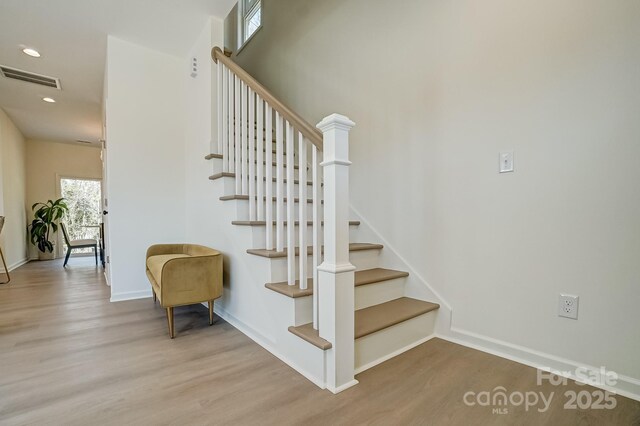 stairway with recessed lighting, visible vents, baseboards, and wood finished floors