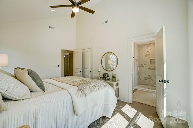 bedroom with a ceiling fan, a high ceiling, wood finished floors, and visible vents