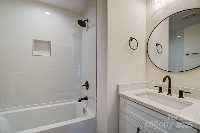 bathroom featuring vanity, visible vents, and shower / bath combination