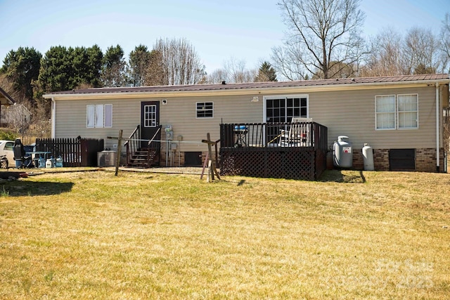 rear view of property with a deck, central air condition unit, metal roof, and a yard