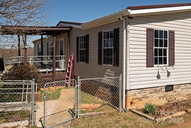 view of property exterior featuring crawl space, fence, and a gate