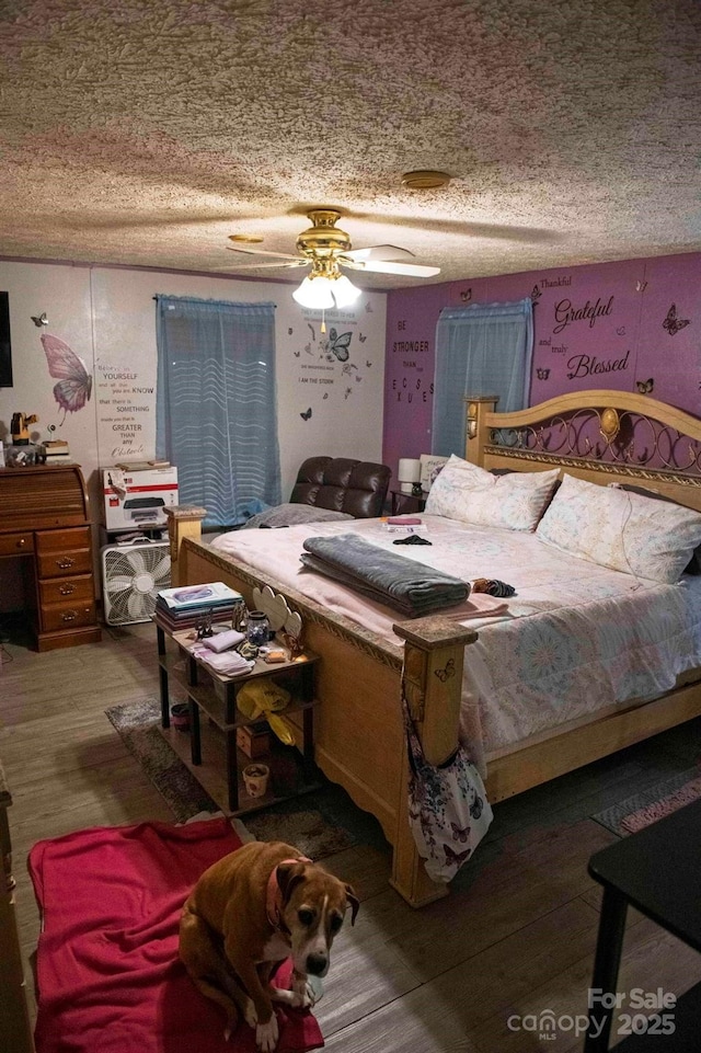 bedroom featuring a textured ceiling, wood finished floors, and ceiling fan