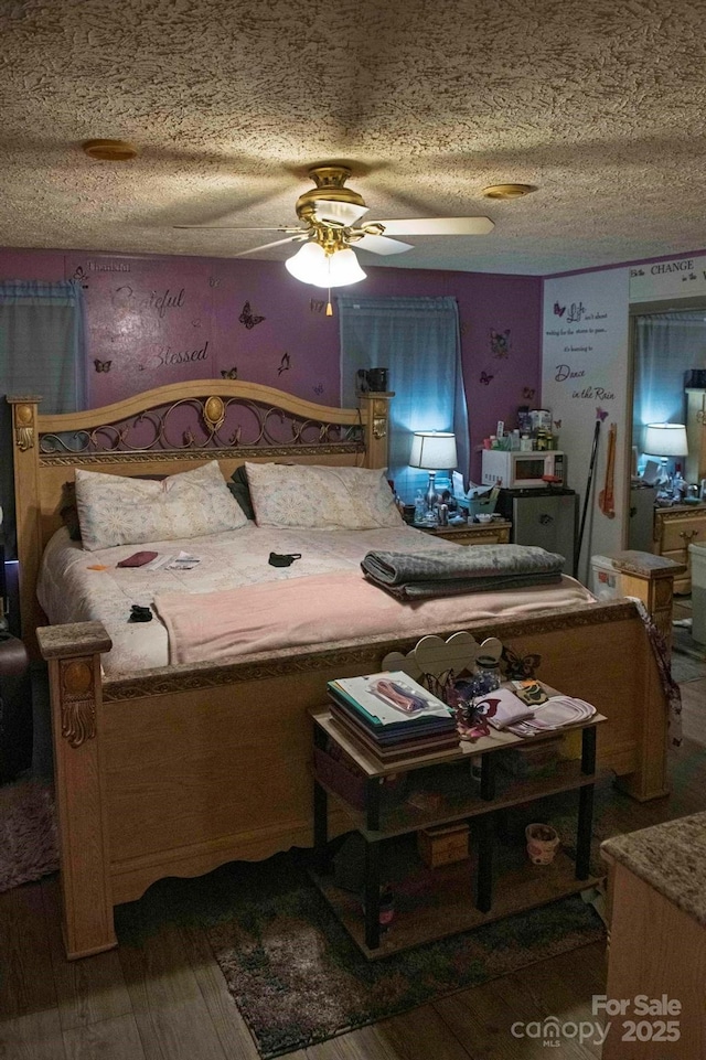 bedroom with a textured ceiling and wood finished floors