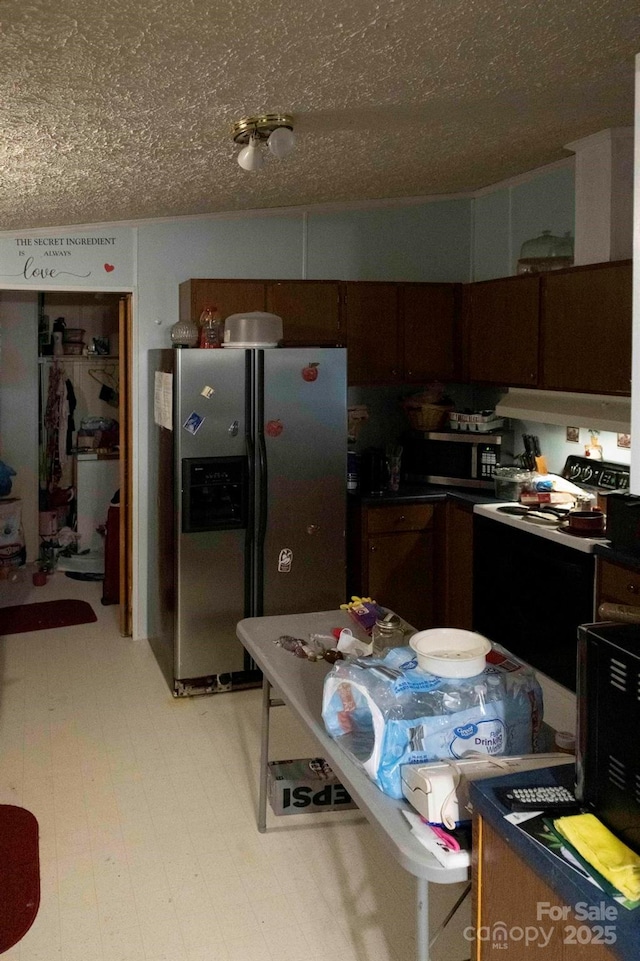 kitchen with stainless steel appliances, dark countertops, and a textured ceiling