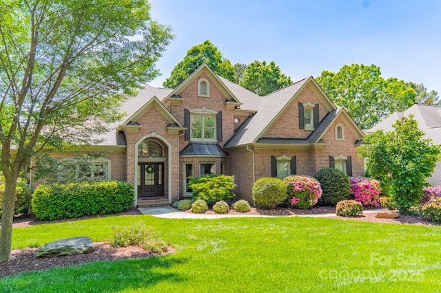 craftsman-style house with a front yard and brick siding