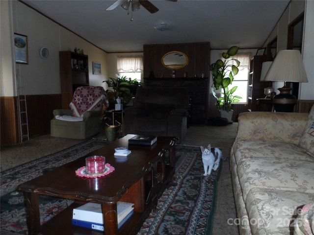 living area with a wainscoted wall, a healthy amount of sunlight, ceiling fan, and carpet flooring