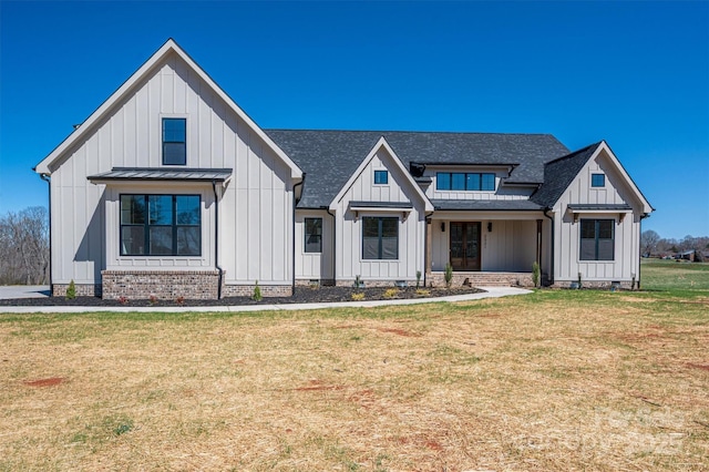 modern inspired farmhouse featuring board and batten siding, a front lawn, roof with shingles, crawl space, and a standing seam roof