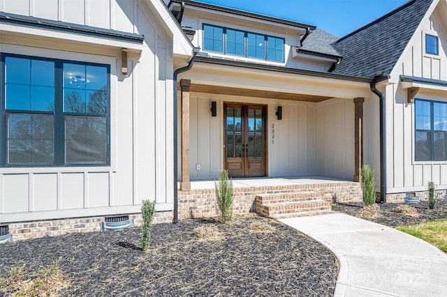 entrance to property with covered porch, a shingled roof, french doors, crawl space, and board and batten siding