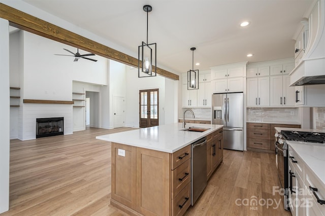 kitchen with light wood-type flooring, a sink, white cabinetry, appliances with stainless steel finishes, and ceiling fan