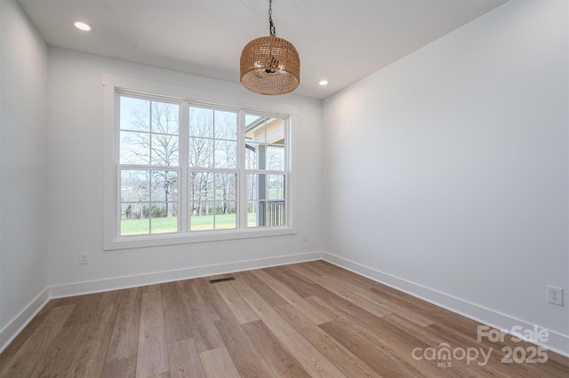 empty room with recessed lighting, visible vents, baseboards, and wood finished floors