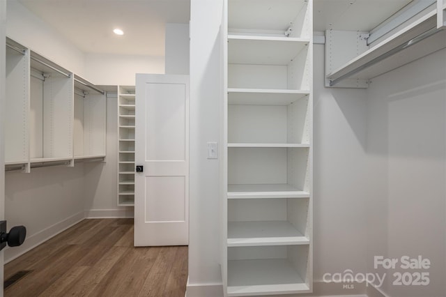 spacious closet featuring visible vents and wood finished floors