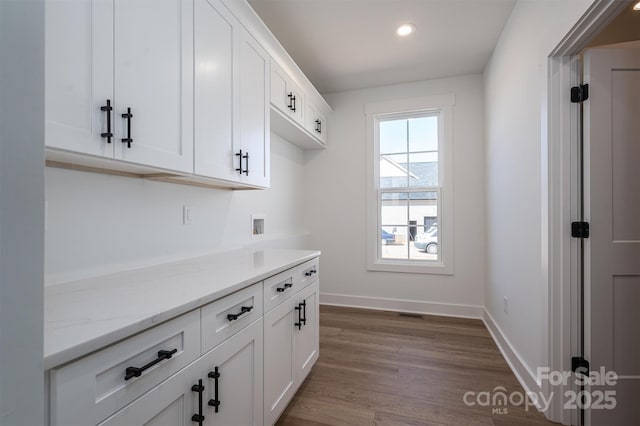 interior space with light stone counters, dark wood finished floors, recessed lighting, white cabinets, and baseboards