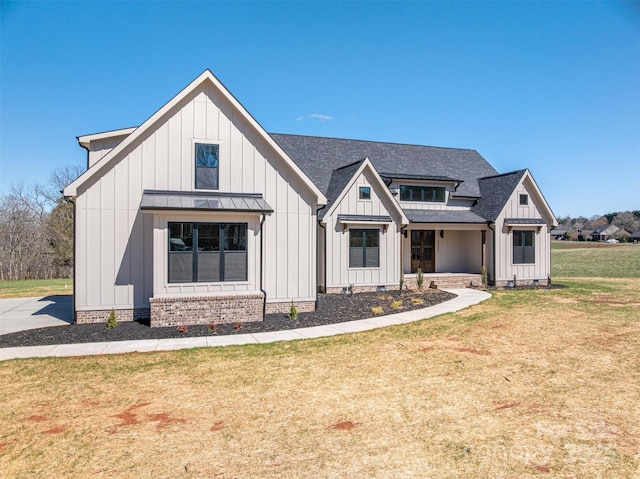 modern farmhouse featuring a standing seam roof, board and batten siding, a front yard, a shingled roof, and crawl space