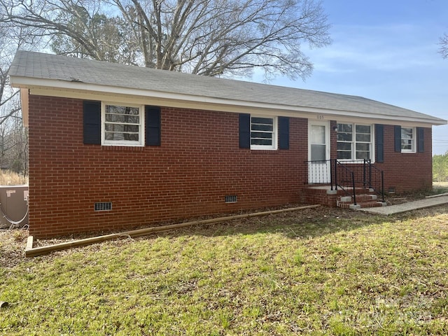 view of front of home with crawl space, central air condition unit, a front lawn, and brick siding