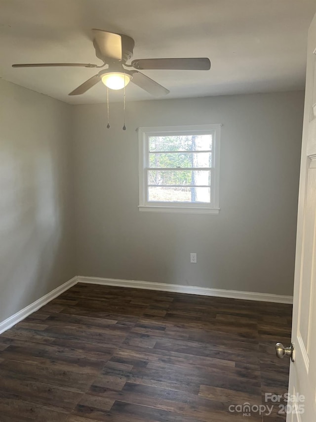 unfurnished room featuring baseboards, dark wood-type flooring, and ceiling fan