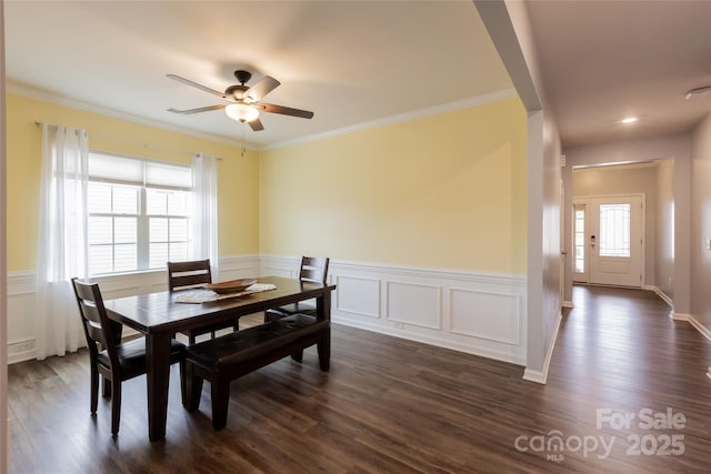 dining area with ornamental molding and dark wood-style flooring