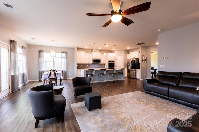 living room featuring visible vents and dark wood-type flooring