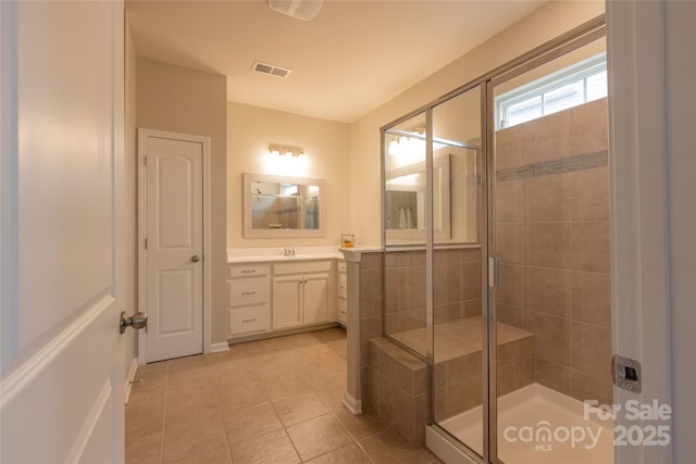 full bath with vanity, a shower stall, visible vents, and tile patterned flooring