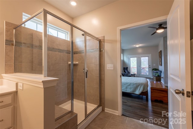 ensuite bathroom with connected bathroom, a stall shower, a ceiling fan, and tile patterned flooring