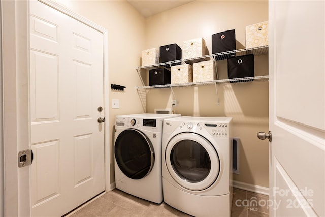 washroom with light tile patterned floors, independent washer and dryer, and laundry area