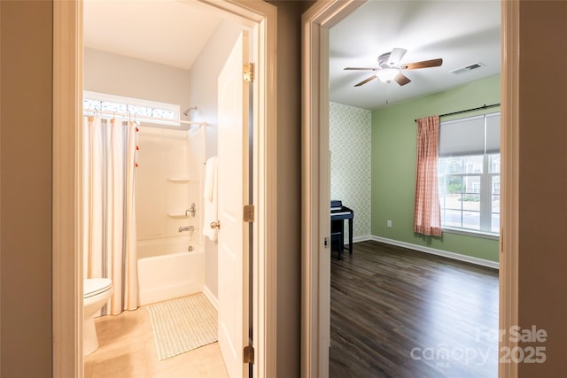 hallway featuring visible vents, baseboards, wood finished floors, and wallpapered walls