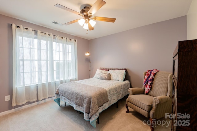 bedroom featuring light carpet, visible vents, and a ceiling fan