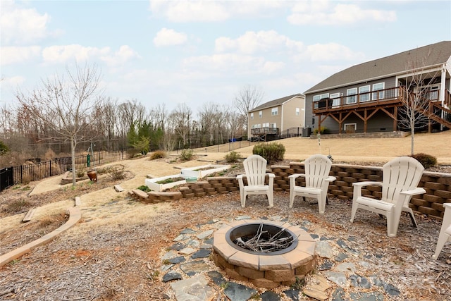 view of patio / terrace featuring a wooden deck, stairway, fence, and an outdoor fire pit