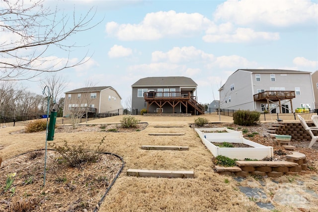 back of property featuring a vegetable garden, a deck, stairs, and fence