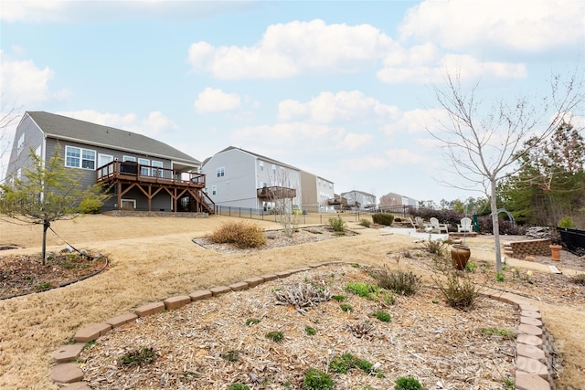 view of yard featuring a deck, stairs, and fence