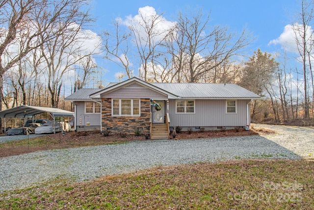 view of front facade featuring driveway, stone siding, metal roof, crawl space, and a carport