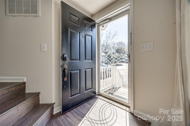 entrance foyer featuring visible vents, a healthy amount of sunlight, dark wood-style flooring, and stairway