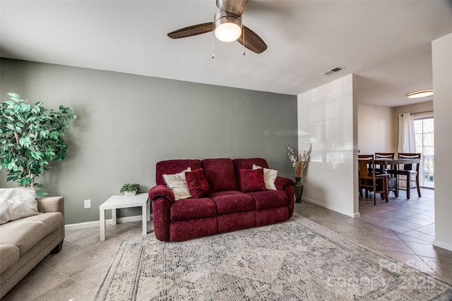 tiled living room with visible vents, a ceiling fan, and baseboards