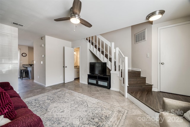 living area featuring visible vents, stairway, and baseboards