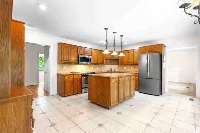 1080 Rolling Green Dr, Newton, NC 28658 - kitchen featuring appliances with stainless steel finishes, brown cabinetry, a center island, backsplash, and a sink