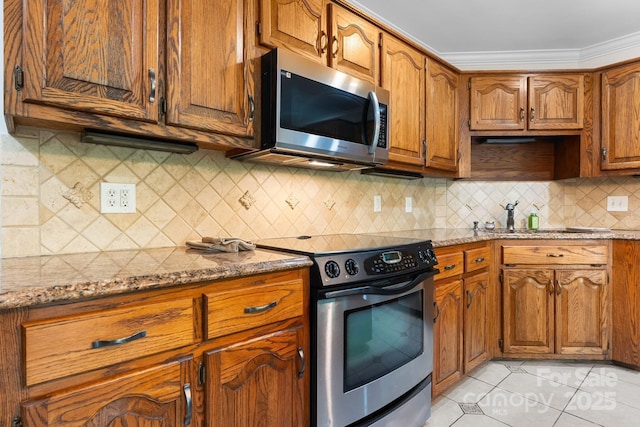 1080 Rolling Green Dr, Newton, NC 28658 - kitchen with stainless steel appliances, brown cabinets, light stone countertops, light tile patterned floors, and ornamental molding