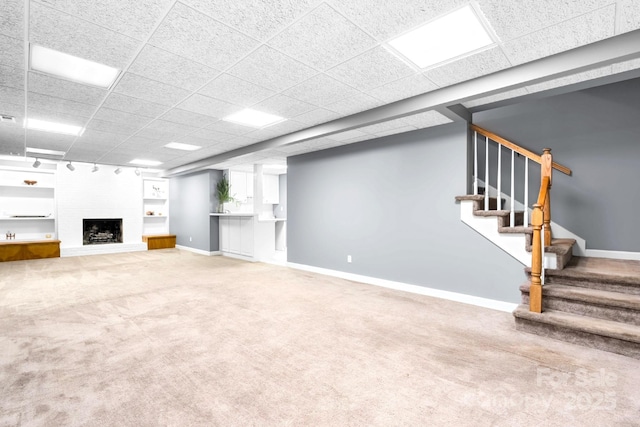 1080 Rolling Green Dr, Newton, NC 28658 - unfurnished living room featuring a drop ceiling, carpet floors, stairs, baseboards, and a large fireplace