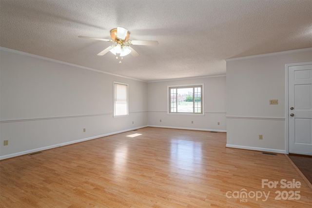 spare room featuring crown molding, light wood-style flooring, baseboards, and ceiling fan