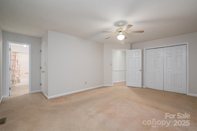 unfurnished bedroom featuring baseboards, light colored carpet, and a textured ceiling