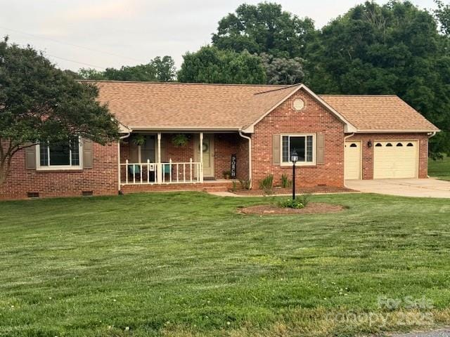 ranch-style house featuring an attached garage, a porch, brick siding, and a front lawn