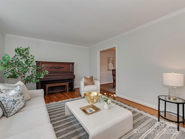 living area with crown molding, wood finished floors, and baseboards