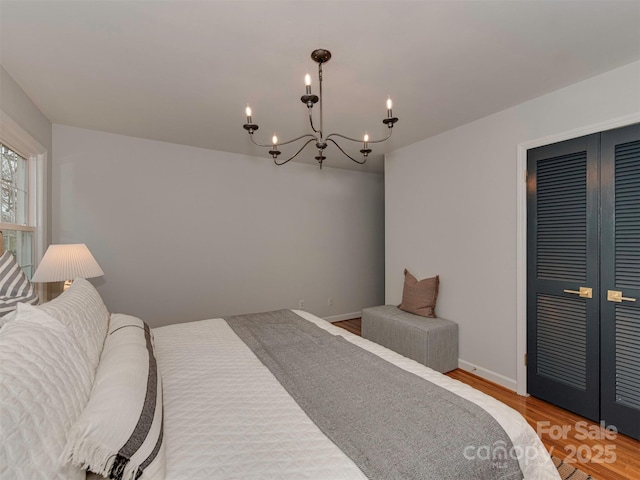 bedroom with wood finished floors, a closet, french doors, and baseboards