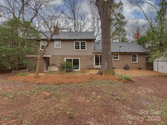 rear view of house with crawl space and brick siding