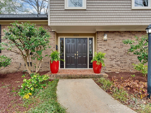 entrance to property with mansard roof and brick siding