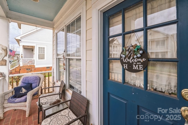 entrance to property featuring a porch and crawl space